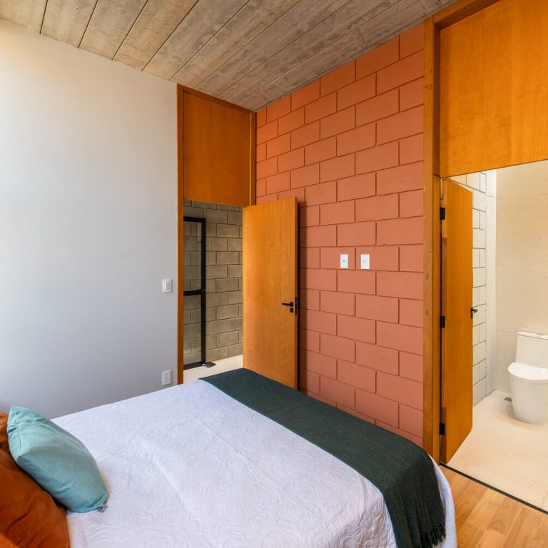 Casa Bohemia en Brasil. habiatcion moderna con baño, muros blancos y de color naranja