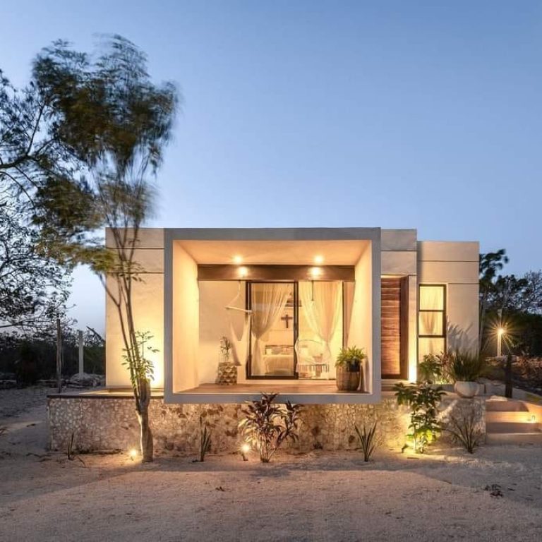 Casa Bungalow en Yucatán: Diseño residencial por V+A Arquitectura. fachada al atardecer con iluminación