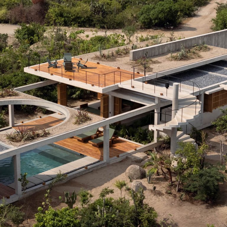 Recorrido exterior entre concreto, madera y vegetación en Casa Cieno