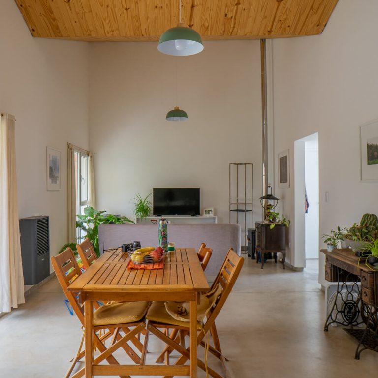 Sala comedor con muros blancos y techo de madera