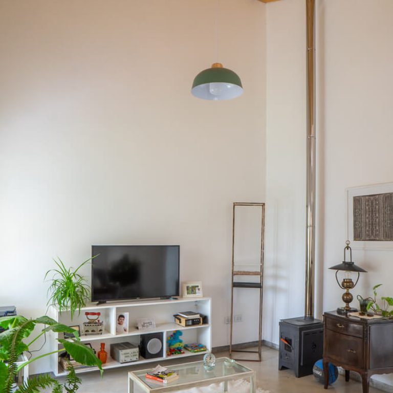 Sala de tv con muros blanco y una lampara colgante