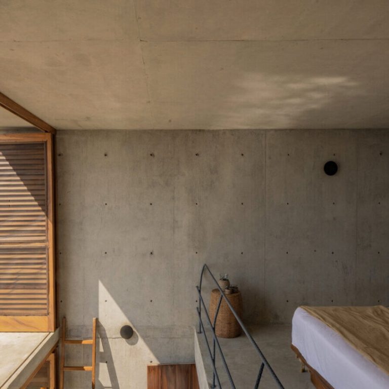 Dormitorio con persianas de madera y vista al mar