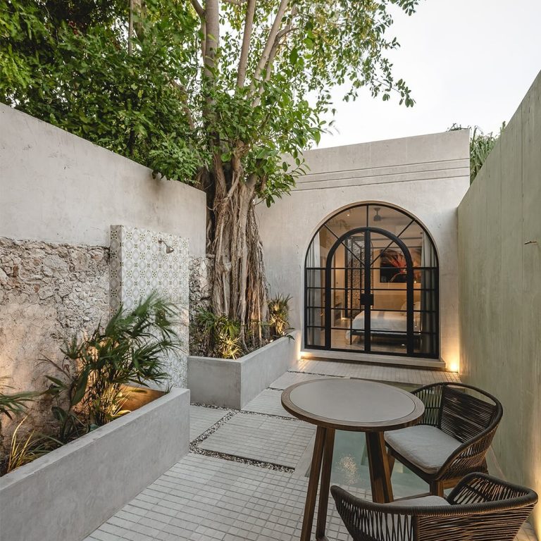 Patio estrecho con puerta ventana en forma de arco. Casa Paradiso en Yucatán