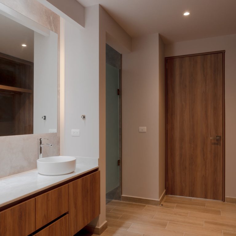 Baño moderno con tono grises y blancos, condos lavabos, espejo y mueble dee madera