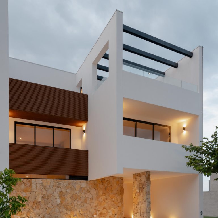 fachada moderna con muros de piedra, color blllanco