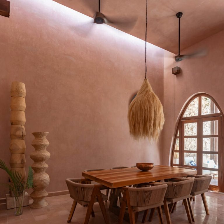La Casa Rosa. Comedor de madera con puerta en forma de arco y luz cenital