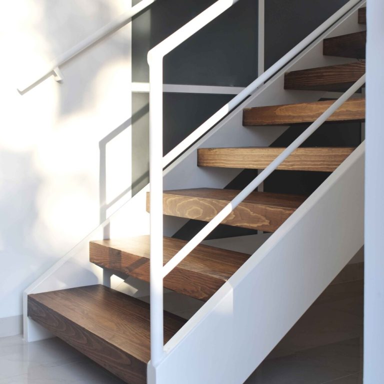 Escalera de acero color blanco con escalones de madera. Reforma Casa AL en Guanajuato