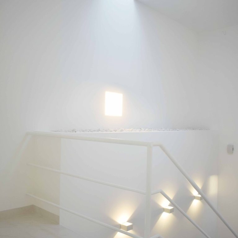 Casa blanca, barandal de acero color blanco, con luminarias de pared. Reforma Casa AL en Guanajuato