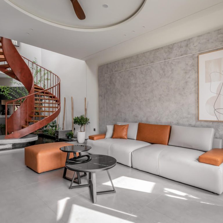 Sala moderna con mobiliario en tonos neutros con escalera helicoidal