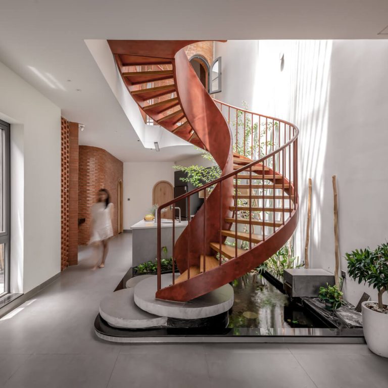 Escalera de caracol moderna color rojo de acero, escalera escultural, jardín interior en escalera