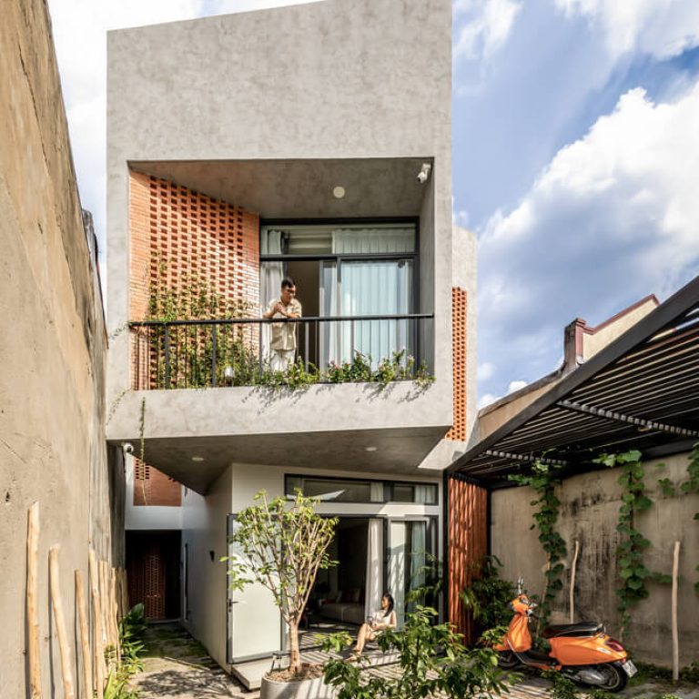 Fachada de casa moderna en vietnam con celosia de barro y concreto pulido