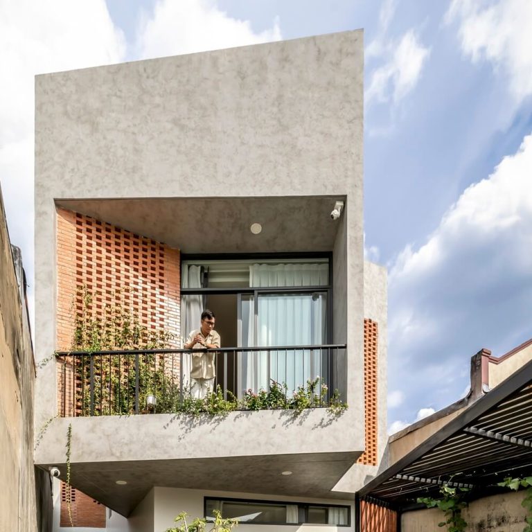 Fachada de casa moderna en vietnam con celosia de barro y concreto pulido