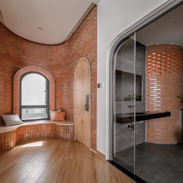 Habitación moderna con ladrillo y un baño moderno con puerta de cristal