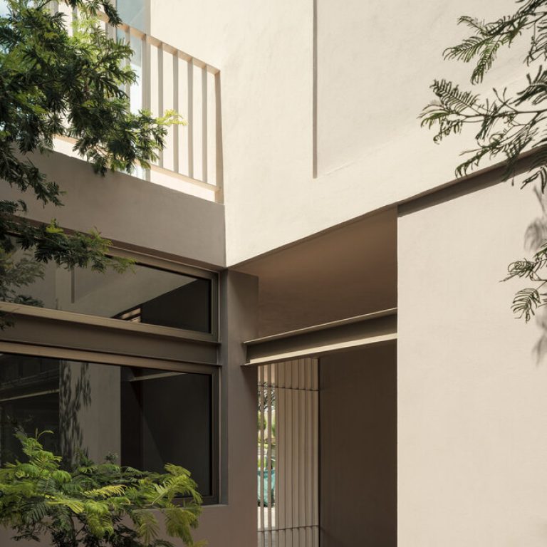 Patio interior con vegetación junto a la fachada de Casa RV
