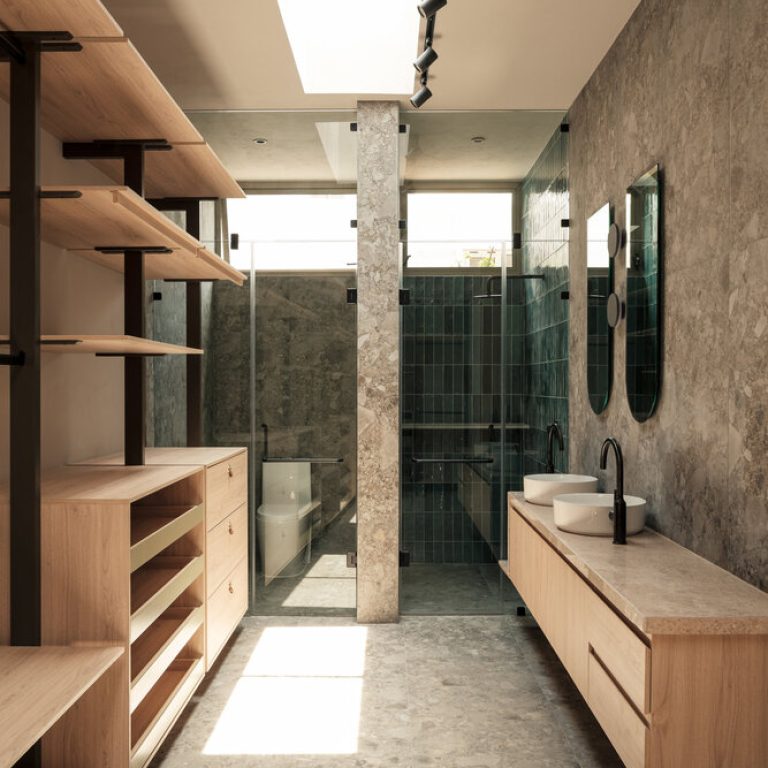 Baño y vestidor de Casa RV con mobiliario de madera y luz cenital